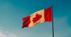 Vancouver Immigration Consultant CIP Canada - Canada flag blowing in wind with blue skies